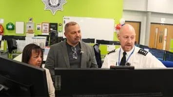 PCC and DPCC looking at screen in control room.