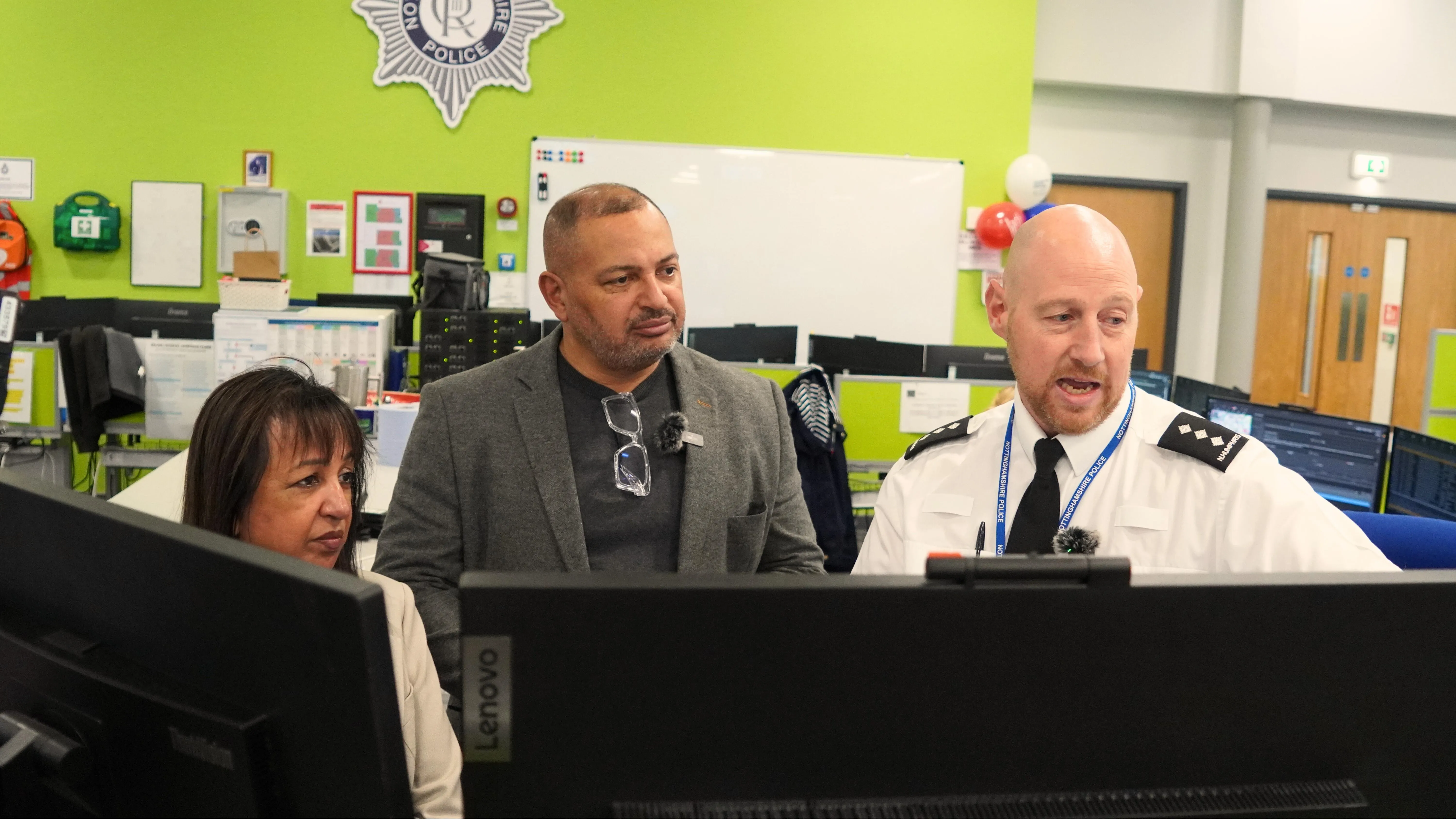 PCC and DPCC looking at screen in control room.