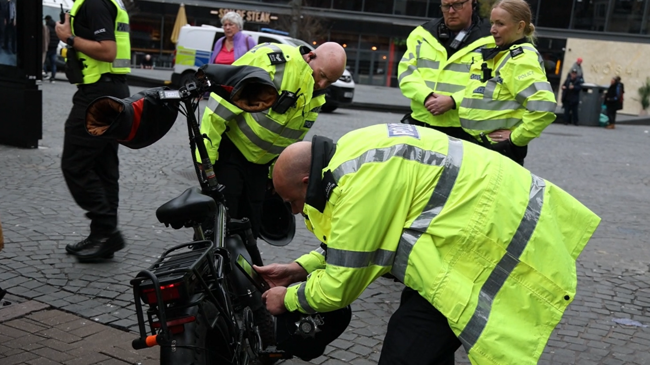 Officers checking an e-bike during a city centre crackdown