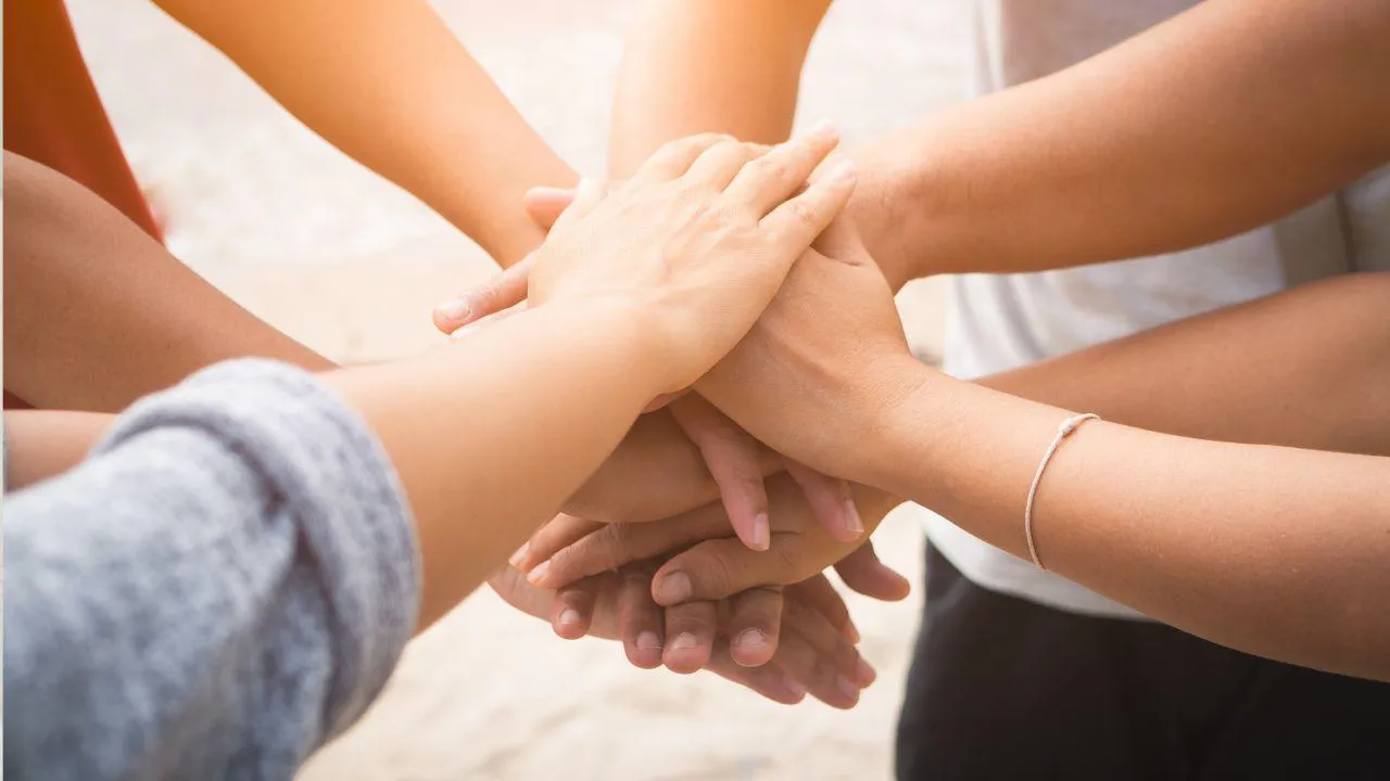 A group of hands coming together as one